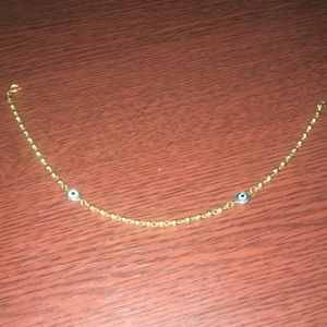 Gold anklet with a turquoise and white design
